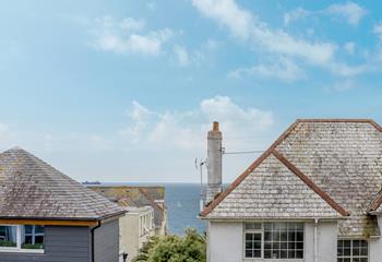 Gaze through the rooftops at the sailboats drifting along in the sea.