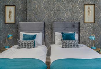 Bright blue decor and luxurious wallpaper make bedroom 1 a gorgeous space to relax.