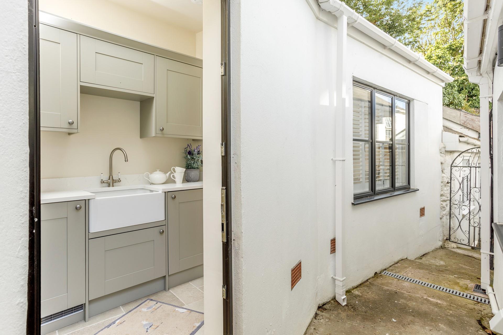 The utility room is at the back of the house, accessed from the kitchen. 