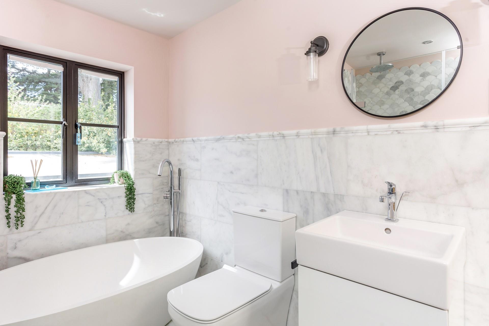 The windows allow natural light to shine through in the bathroom.