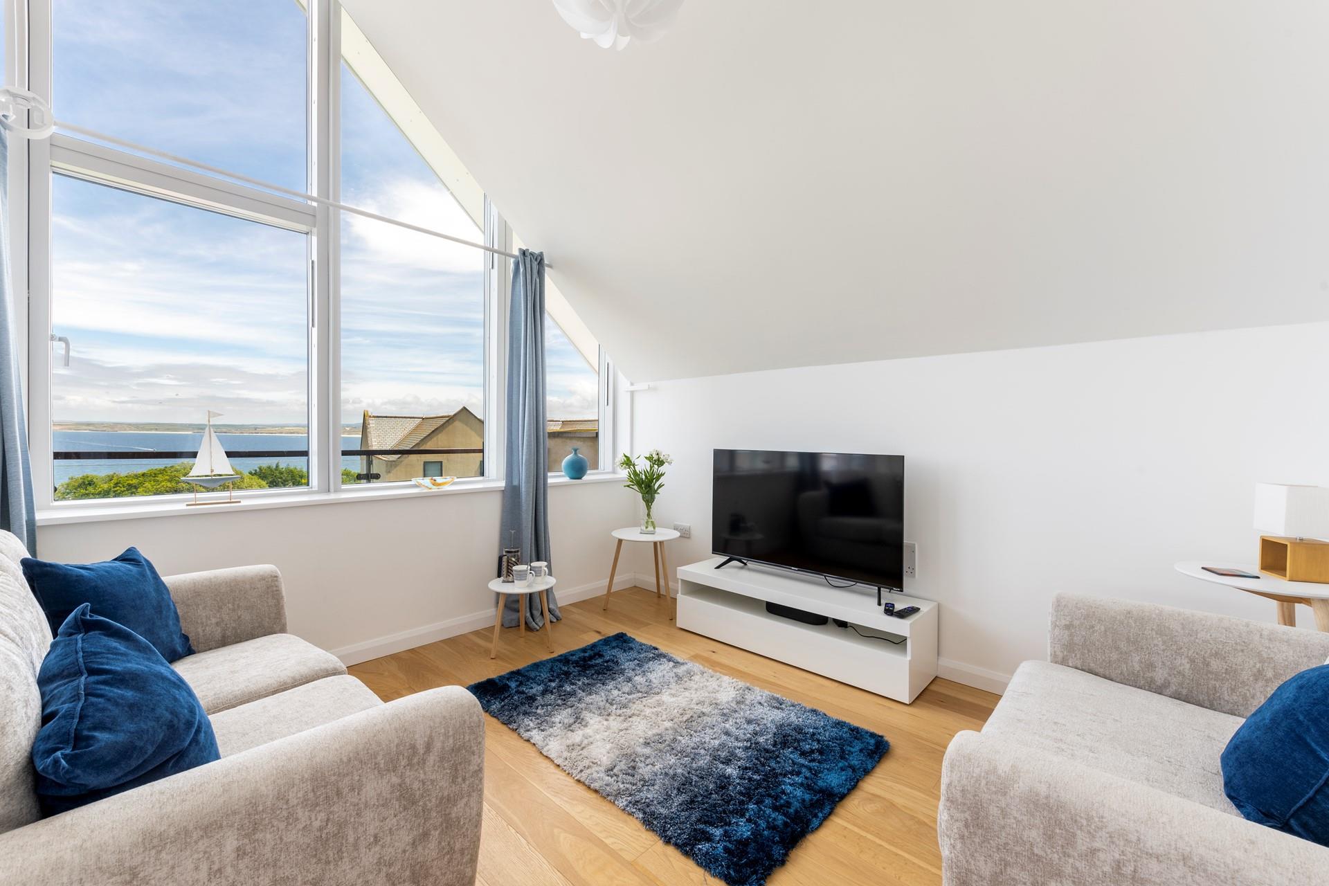 The cosy sitting room has lovely blue and grey interiors creating a calming space to relax.