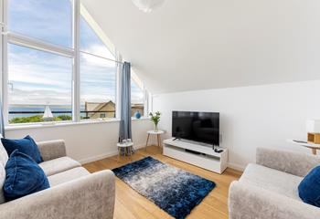 The cosy sitting room has lovely blue and grey interiors creating a calming space to relax.