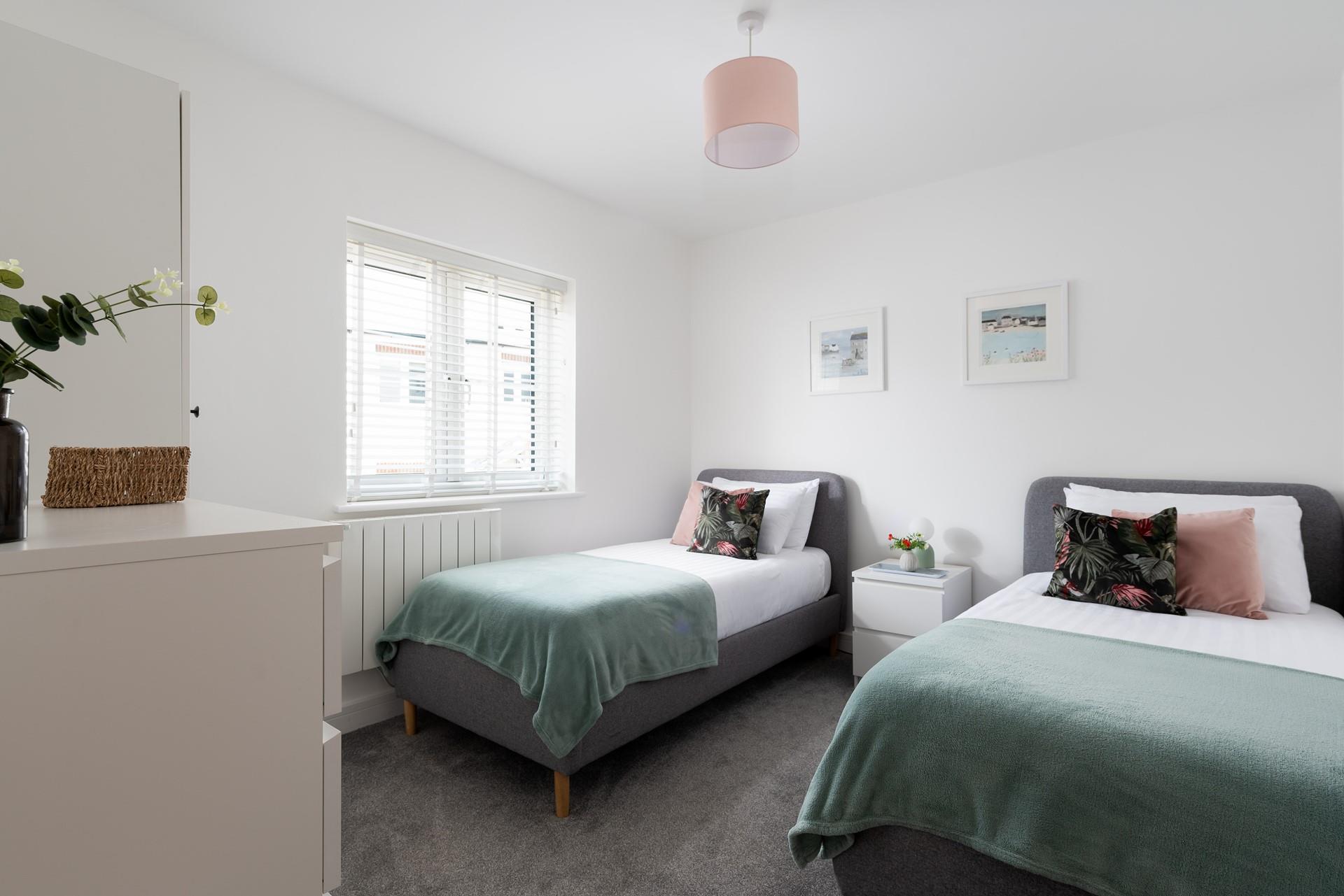 Bedroom 2 has twin beds and is decorated with calming pastel shades.