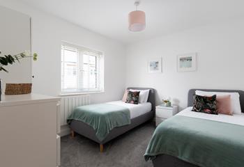 Bedroom 2 has twin beds and is decorated with calming pastel shades.