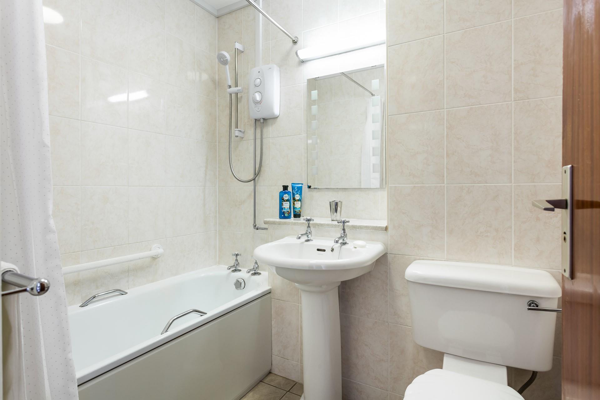 The bathroom has a shower or a bath to choose from each morning.