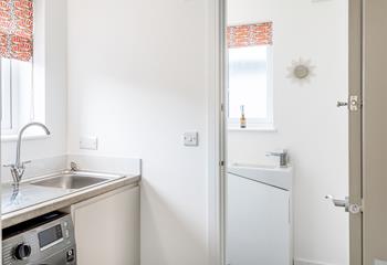 The utility room on the first floor, conveniently located with a washing machine, additional sink and toilet.