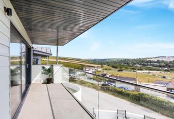 The balcony stretches the width of the house, showcasing the incredible views.