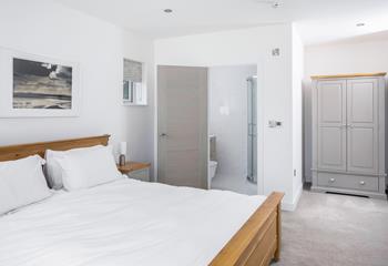 A king size bed, stylish storage and a modern en suite shower make for a relaxing stay in the master bedroom.