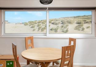 Stunning sea views of the sand dunes are the backdrop to your holiday mealtimes.