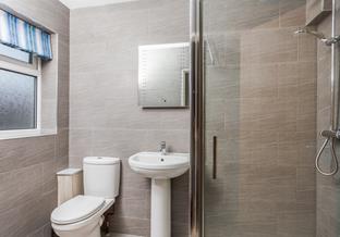 Wash away beach days in the modern bathroom with ample shower.