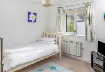 Light and bright, the single bedroom boasts a comfortable bed.