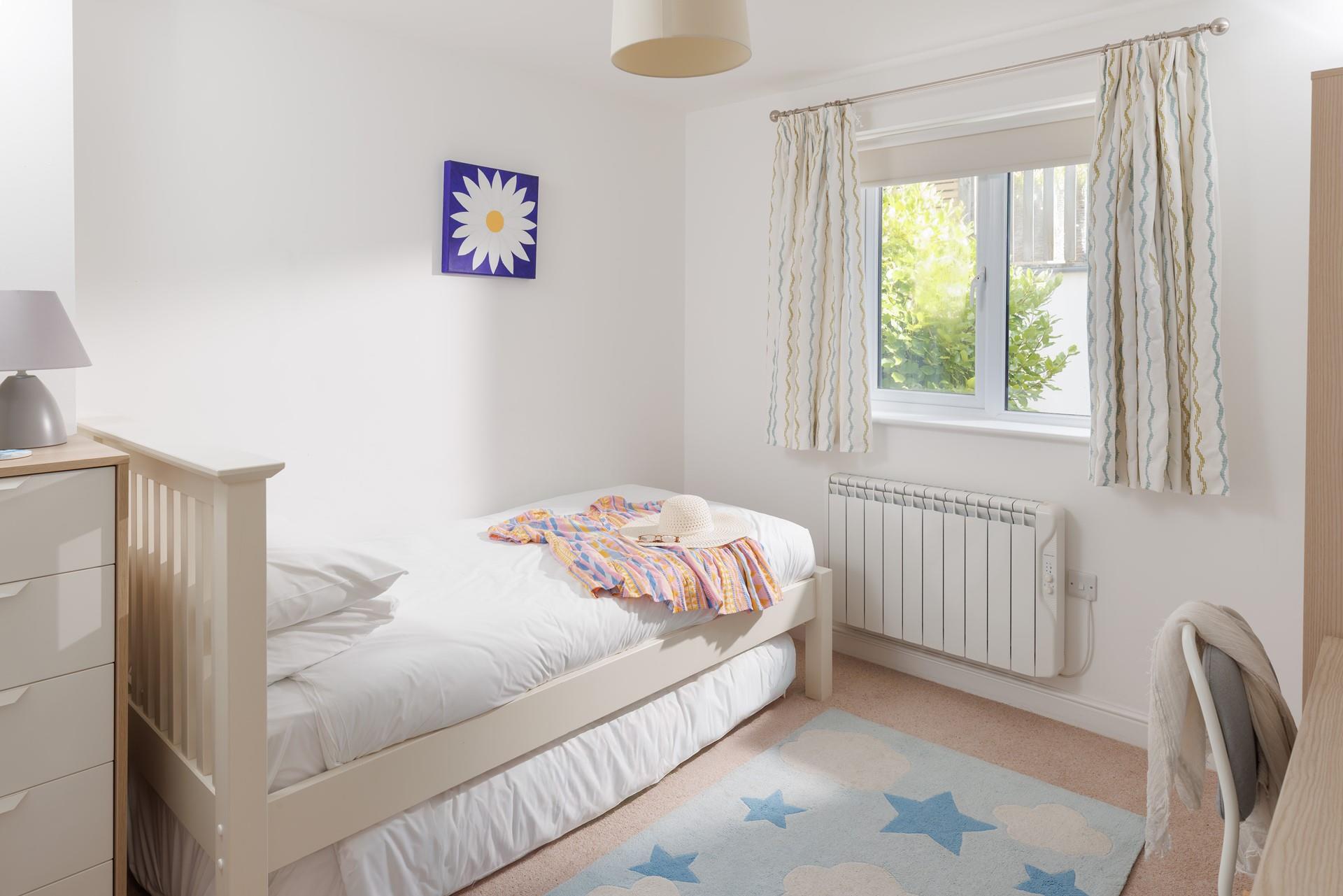 Light and bright, the single bedroom boasts a comfortable bed.