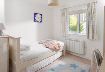 Light and bright, the single bedroom boasts a comfortable bed.