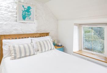 A double bedroom with quirky coastal artwork and more of the classic cottage feel.