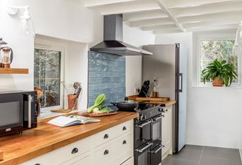 A spacious galley-style kitchen with range cooker and slate floors.