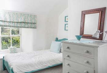 The twin bedroom is a serene and snug spot for kids or young adults.