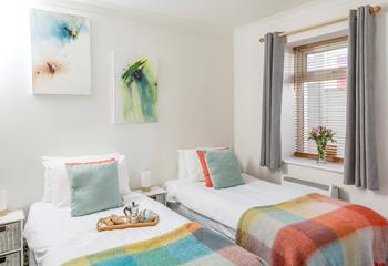 Splashes of colour adorn the comfortable twin bedroom.