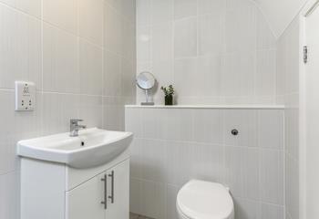 Stylish minimalism and useful storage in the en suite bathroom.