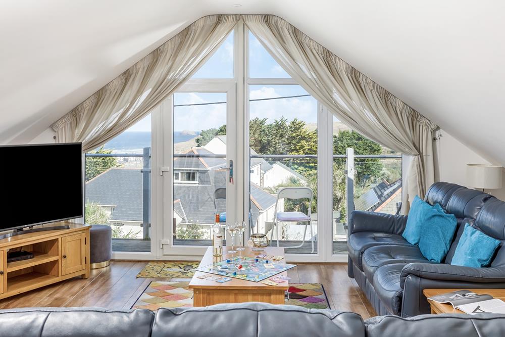 Floor to ceiling windows offer sweeping views across Perranporth and out to sea.