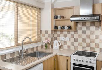 The compact kitchen is fully-equipped with all you need for a relaxing stay.