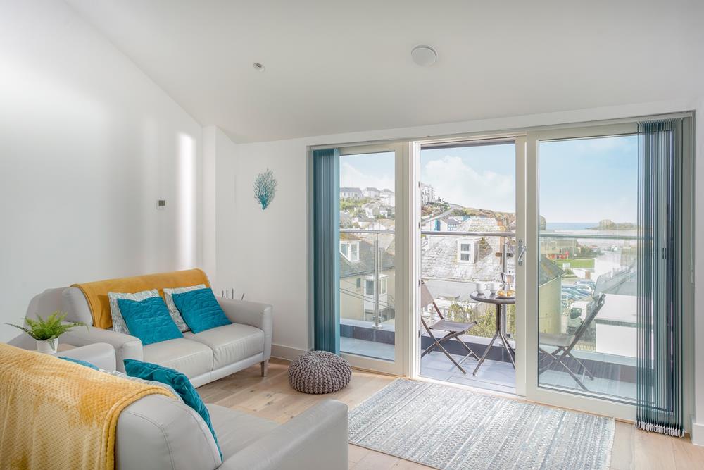 The relaxing seating area offers stunning sea views through the expansive balcony doors.