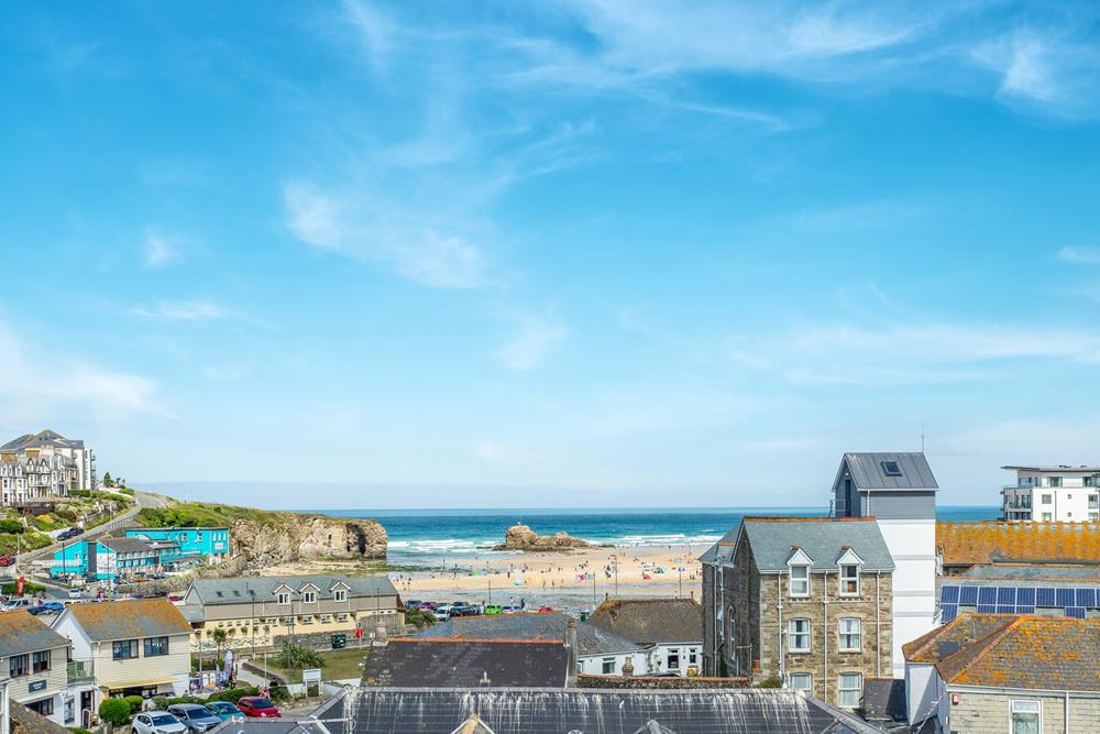 Views across the rooftops reveal the iconic Chapel Rock on Perranporth beach.