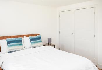 The master bedroom is simple, yet stylish with coastal blue accents. 