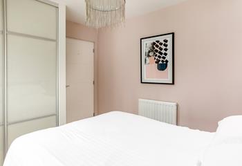 Abstract art and feature lighting in the double bedroom create a serene space for a dreamy night's sleep.