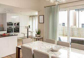 The contemporary kitchen is just off the dining area, with access to the balcony and extra seating for two!