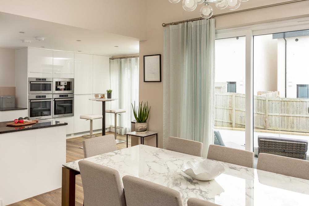 The contemporary kitchen is just off the dining area, with access to the balcony and extra seating for two!