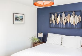 Coastal colours and local artwork add a touch of style to the bedroom.