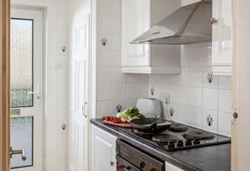 The light and bright kitchen is compact and well-equipped.