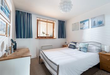 The bedroom has a spacious king size bed decorated with lovely blue tones.