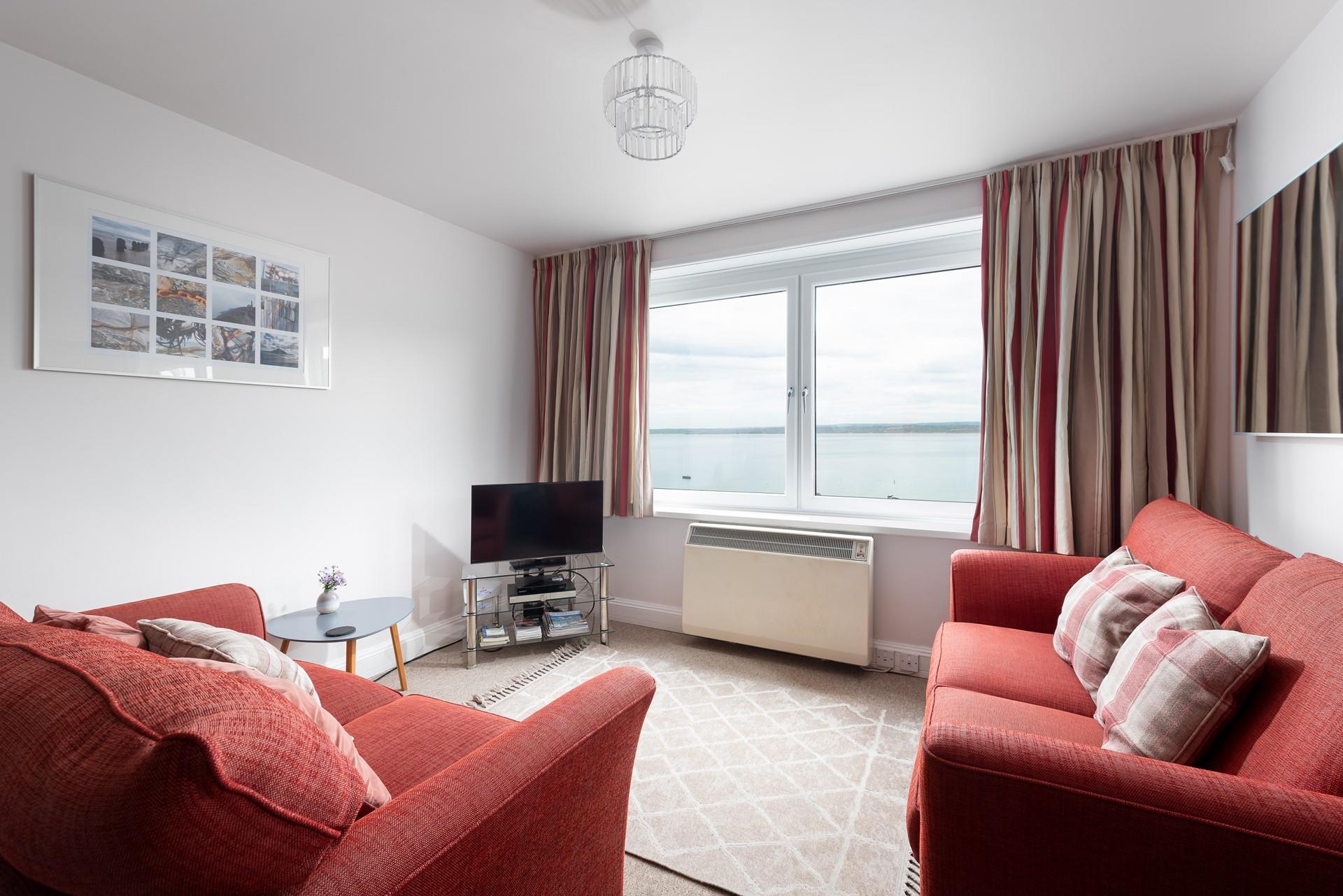 The sitting room is decorated with bright furnishings and plush sofas.