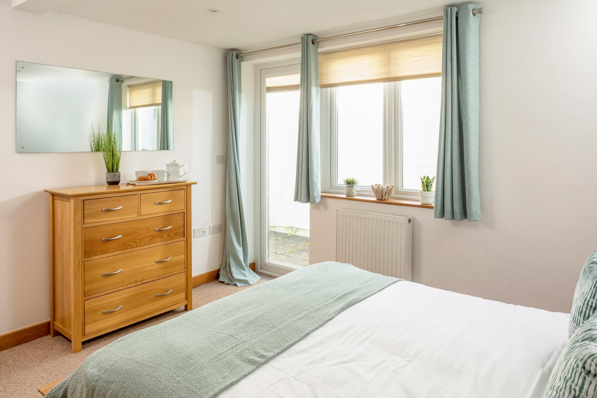 A door from bedroom 1 opens out to a small lower patio, an ideal spot for keeping your beach gear.