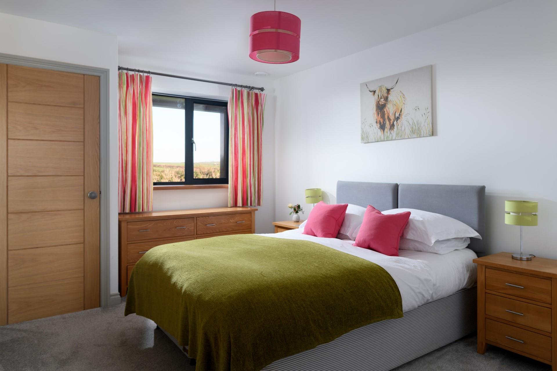 A bright and cheerful bedroom, we love the highland cow artwork!