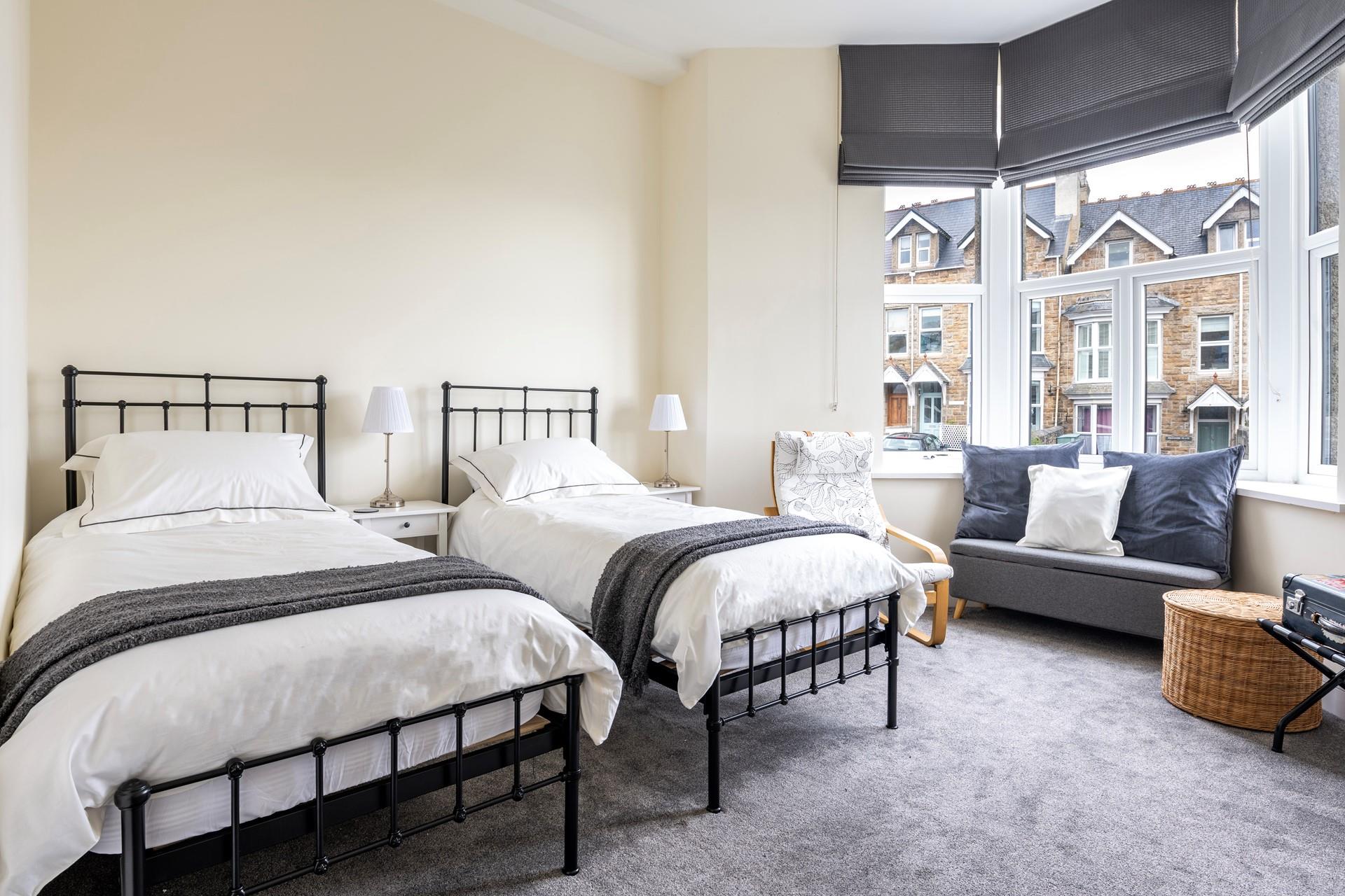 Bedroom 1 is filled with light from the large bay window.
