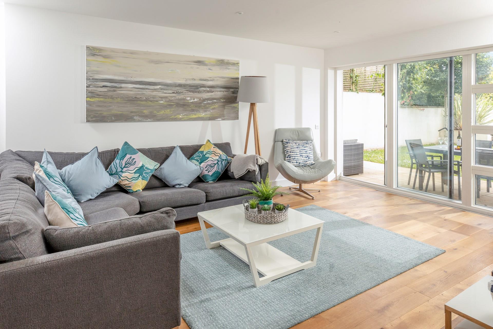 The open plan living space has an ocean theme and blue cushions to reflect the close proximity to the sea.