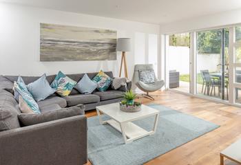 The open plan living space has an ocean theme and blue cushions to reflect the close proximity to the sea.