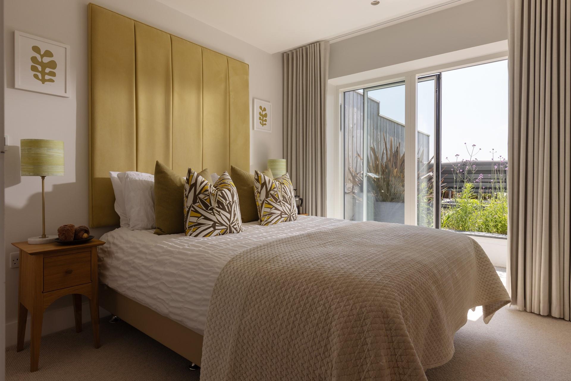 Bedroom 3 is on the ground floor, boasting a comfortable king size bed and doors out to the garden.