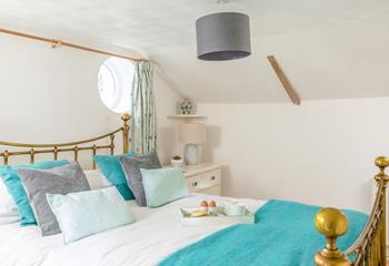 The lovely master bedroom has quirky porthole windows and allows for a comfortable night's sleep.