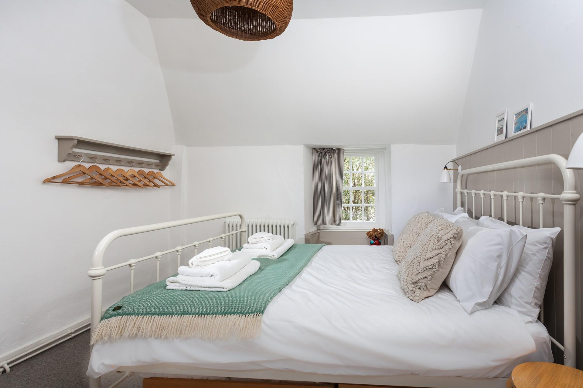 There are hooks for hanging up clothes in the comfortable bedroom.