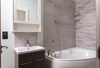The family bathroom is on the first floor and boasts a corner bath with shower attachment.