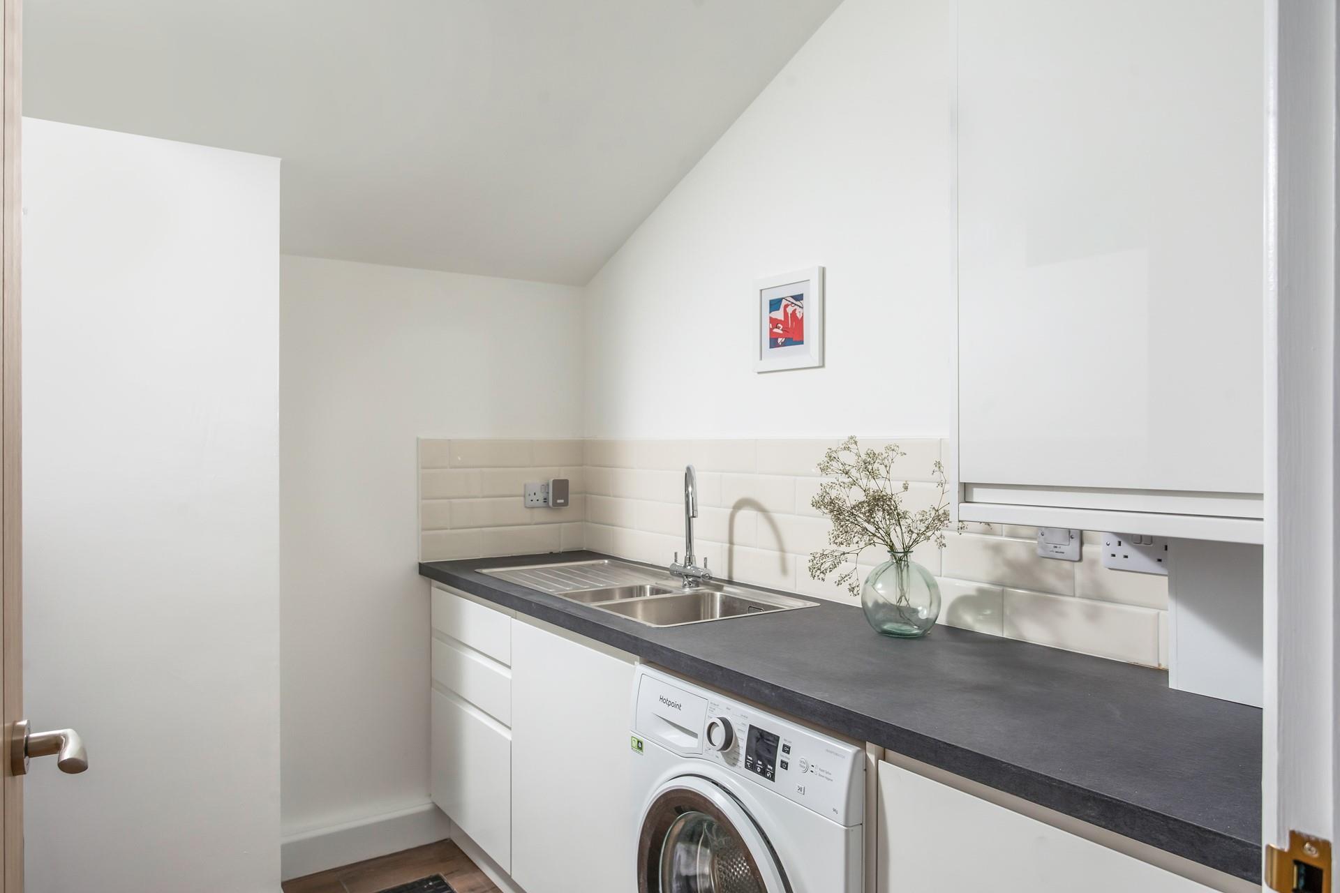 The utility kitchen has a washing machine and a tumble dryer.