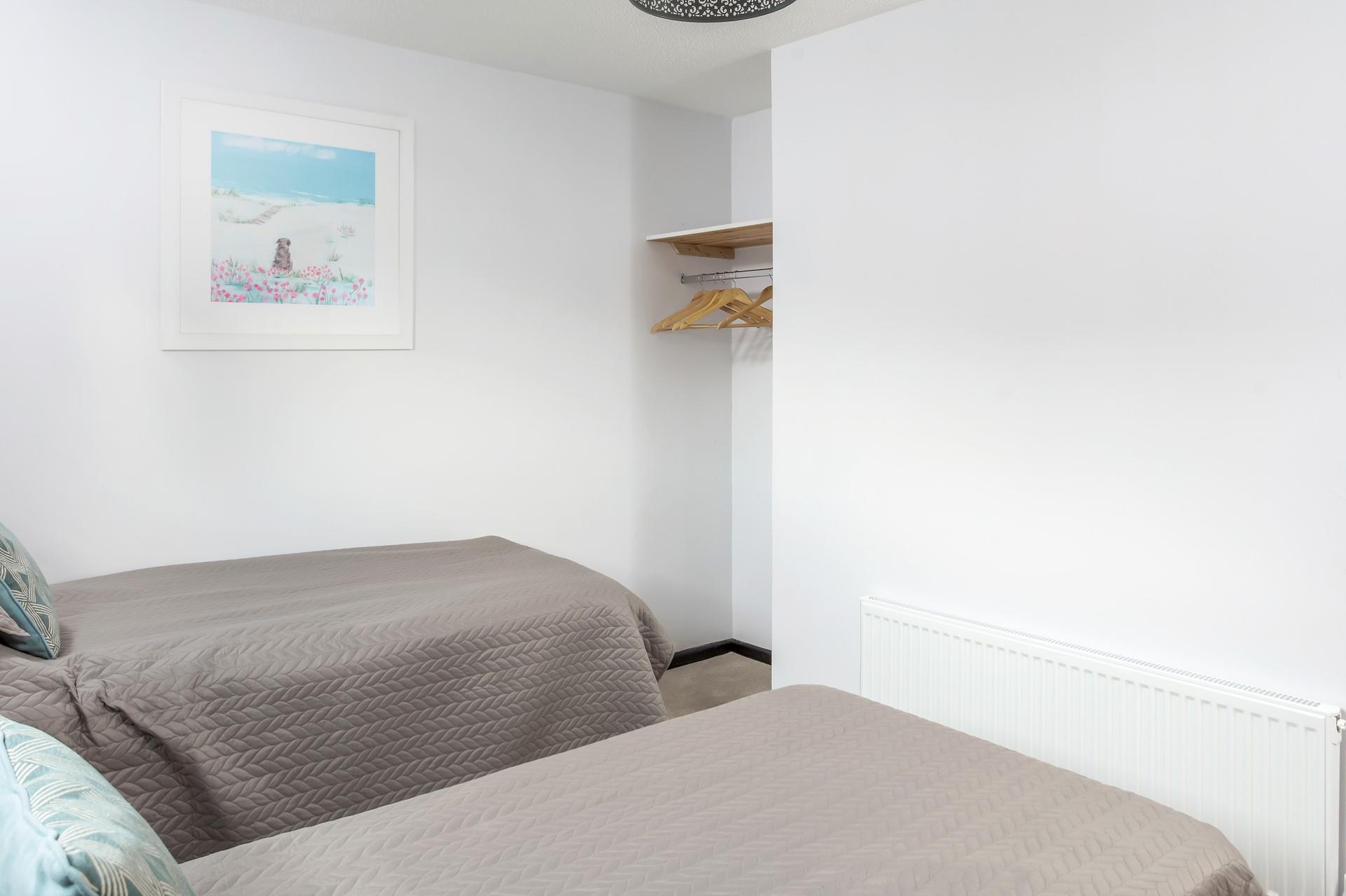 Bedroom 2 has hanging space and coastal-inspired artwork.