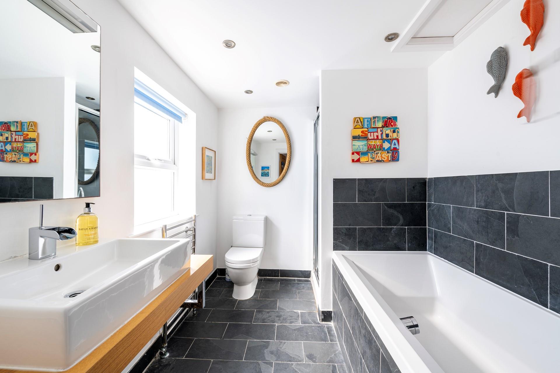 The bathroom has a separate rainfall shower for washing sandy toes and a bath to relax and unwind.