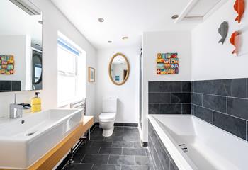 The bathroom has a separate rainfall shower for washing sandy toes and a bath to relax and unwind.