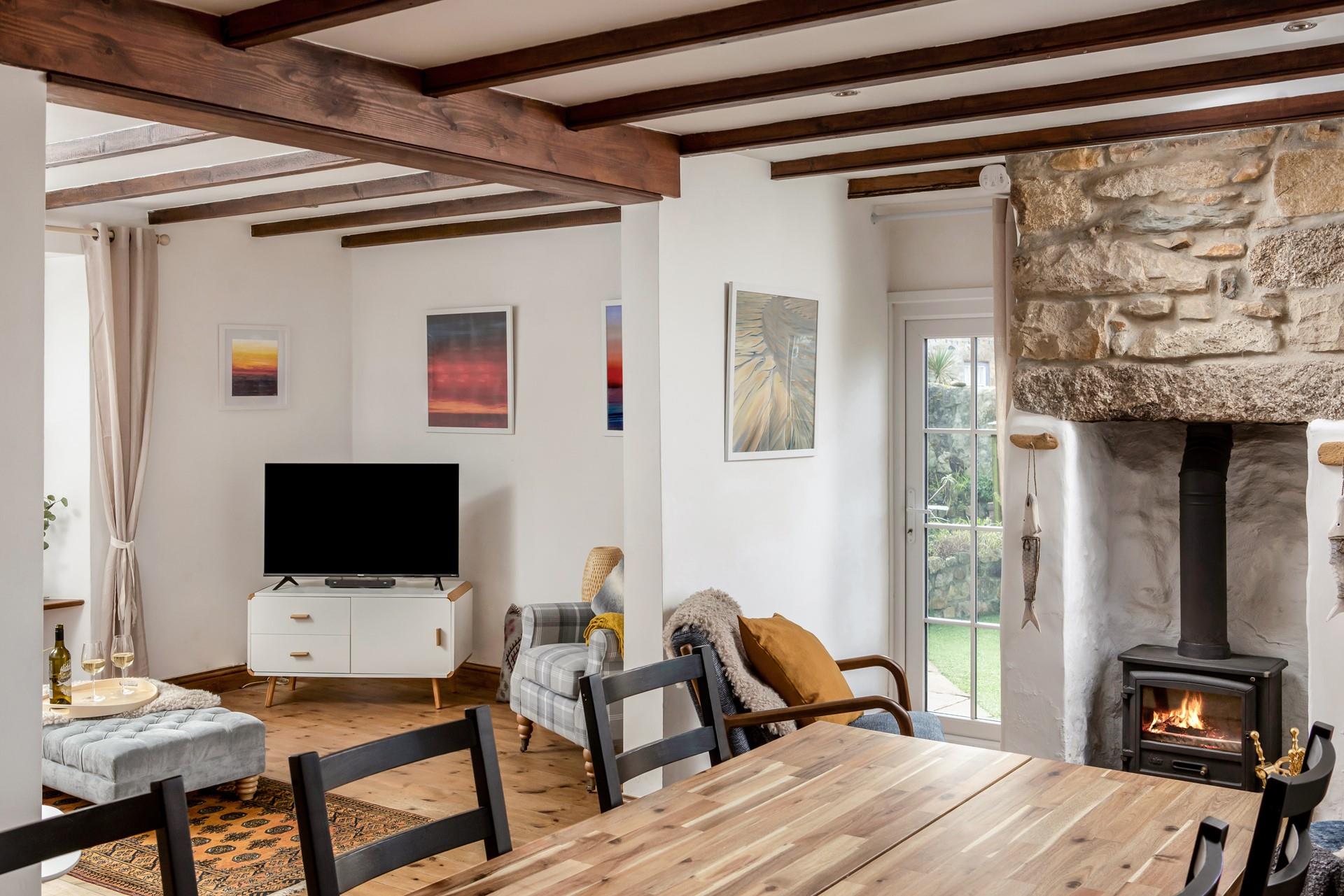 The bright open plan living space at Trewinel Cottage with a door to the enclosed garden. 