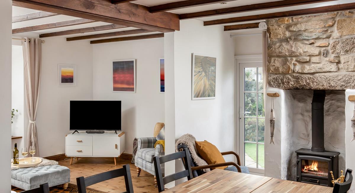 The bright open plan living space at Trewinel Cottage with a door to the enclosed garden. 