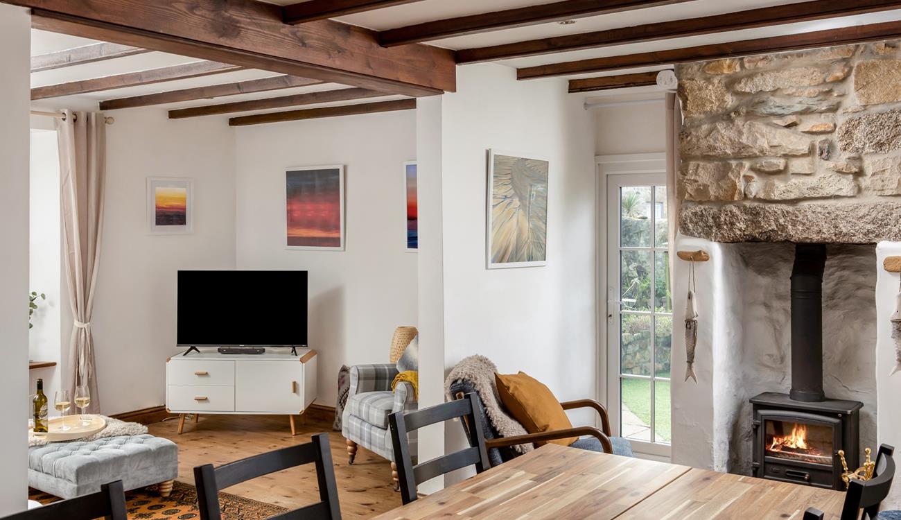 The bright open plan living space at Trewinel Cottage with a door to the enclosed garden. 